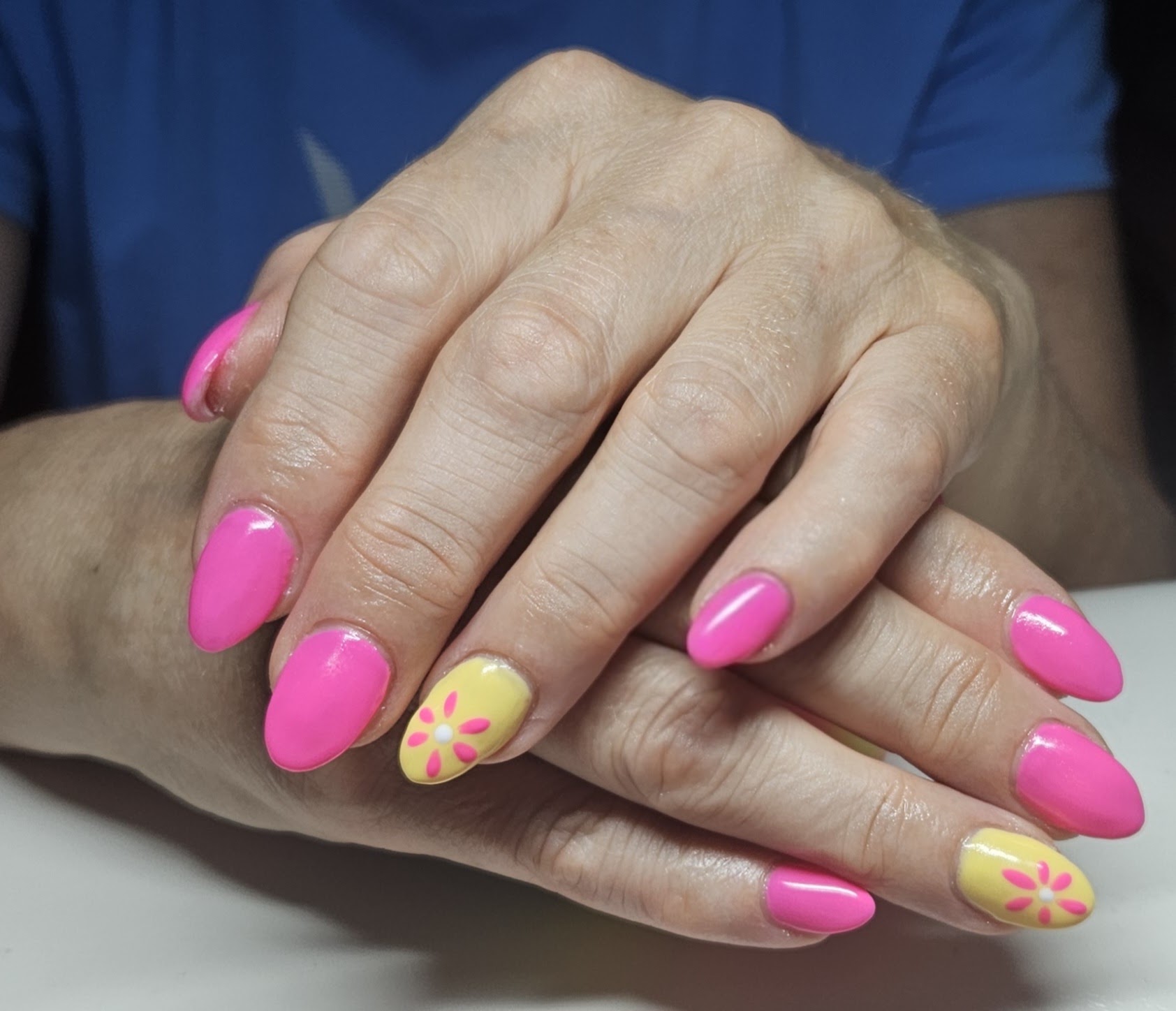 Roze amandelvormige nagels, twee nagels geel met een roze bloemetje