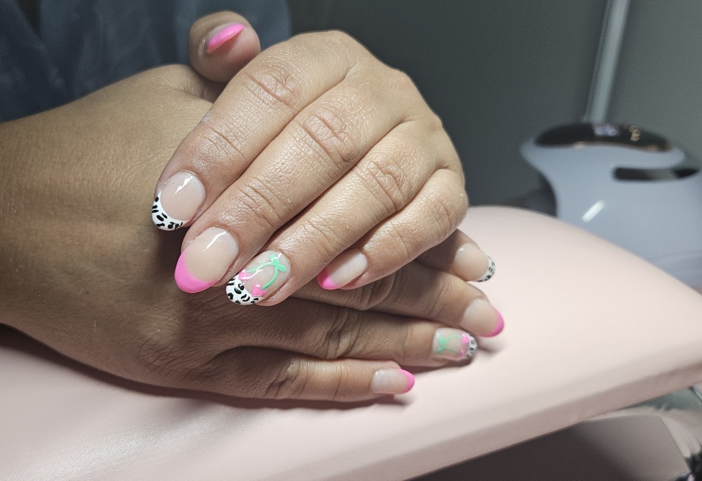 Nagels met een roze French, zwart-witte luipaardtipjes en een kersje